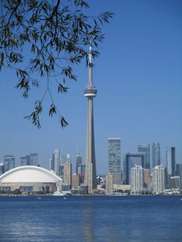 Iconic Toronto skyline featuring the CN Tower above the waterfront and skyscrapers.