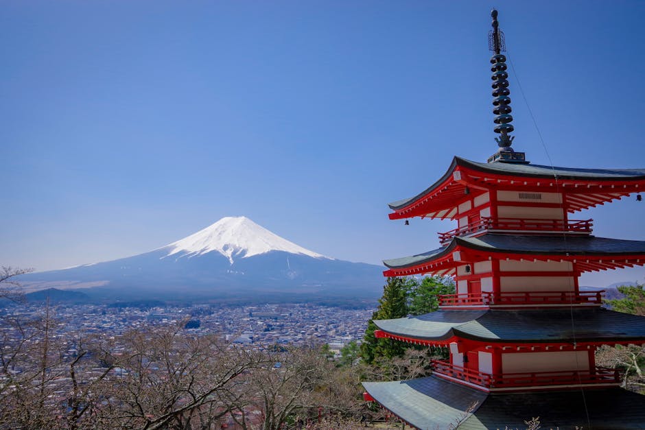 Iconic view of Mount Fuji with Chureito Pagoda in Yamanashi, Japan, under a bright blue sky.