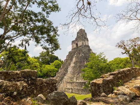 Explore the ancient Mayan architecture of Tikal's Great Jaguar Pyramid surrounded by lush jungle.