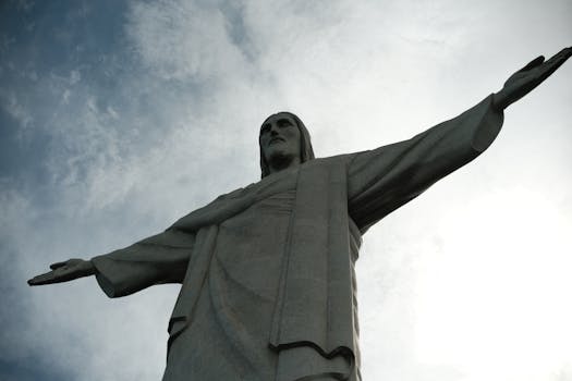 Iconic Christ the Redeemer statue with arms outstretched against a blue sky in Rio de Janeiro, Brazil.