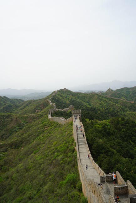 Stunning aerial view of the Great Wall of China stretching across lush green mountains.