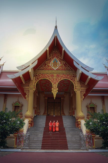 A stunning view of a temple in Laos with Buddhist monks standing on steps, showcasing cultural beauty.
