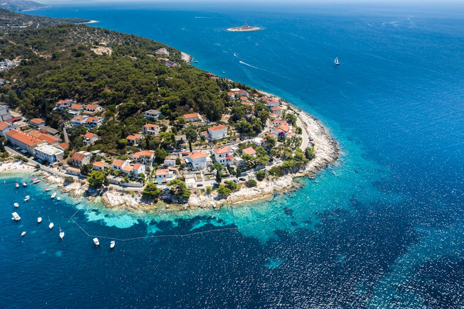 Stunning aerial view of a coastal town in Croatia with turquoise waters and lush greenery.