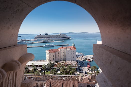 View of a cruise ship in Split, Croatia from an arched stone window, showcasing summer sea beauty.