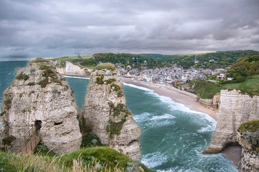Breathtaking view of Étretat's white cliffs and coastal town in Normandy, France.