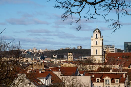 A beautiful view of Vilnius city featuring historic architecture and a prominent church tower under a clear sky.