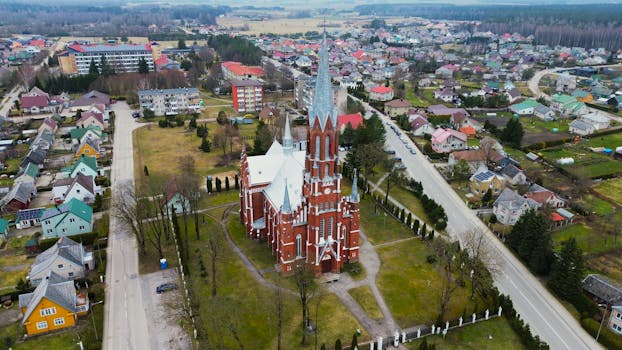 Drone shot capturing the historic St. Francis of Assisi Church amid the urban landscape of Šilalė, Lithuania.