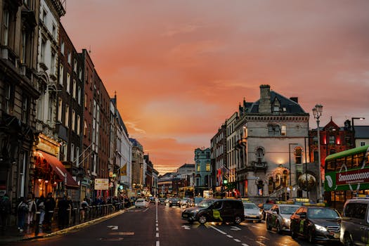 Vibrant city street in Dublin, Ireland during a stunning sunset, showcasing urban life.