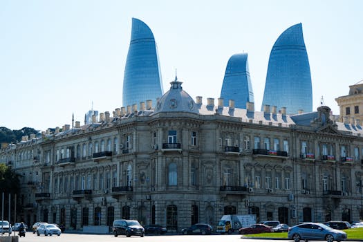 Scenic view of Baku's Flame Towers behind a historic building during the day.