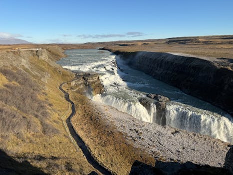Breathtaking view of the Gullfoss waterfall cascading in Iceland under clear blue skies.