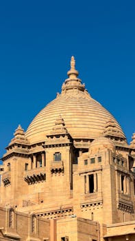View of the stunning dome of Umaid Bhawan Palace against a clear blue sky in Jodhpur, India.