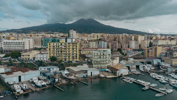 Scenic aerial shot of Naples, Italy with Mount Vesuvius in the background under cloudy skies.