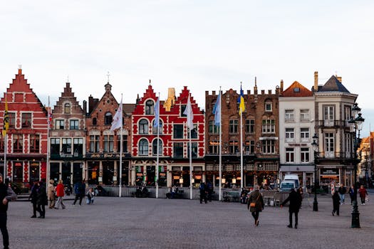 Vibrant medieval buildings lining a square in Bruges, showcasing Flemish architecture.